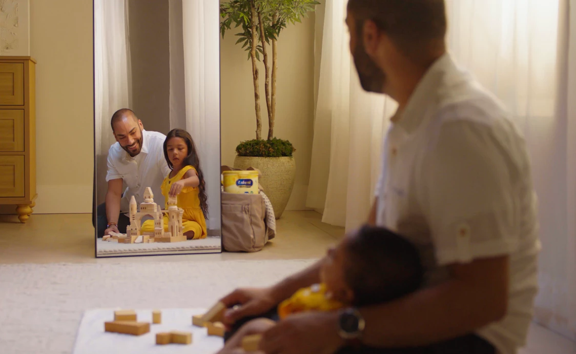 Dad sitting in floor in front of mirror with baby