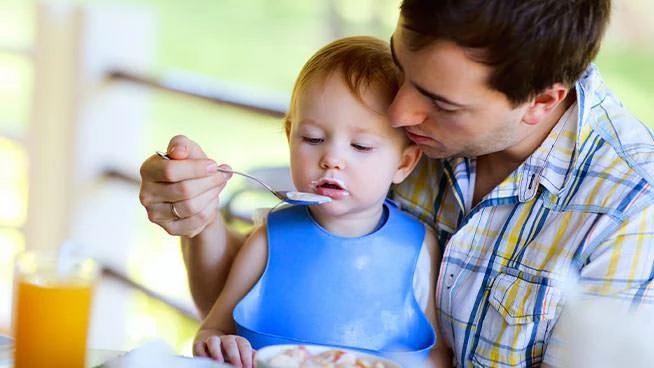 Dad feeding picky toddler boy