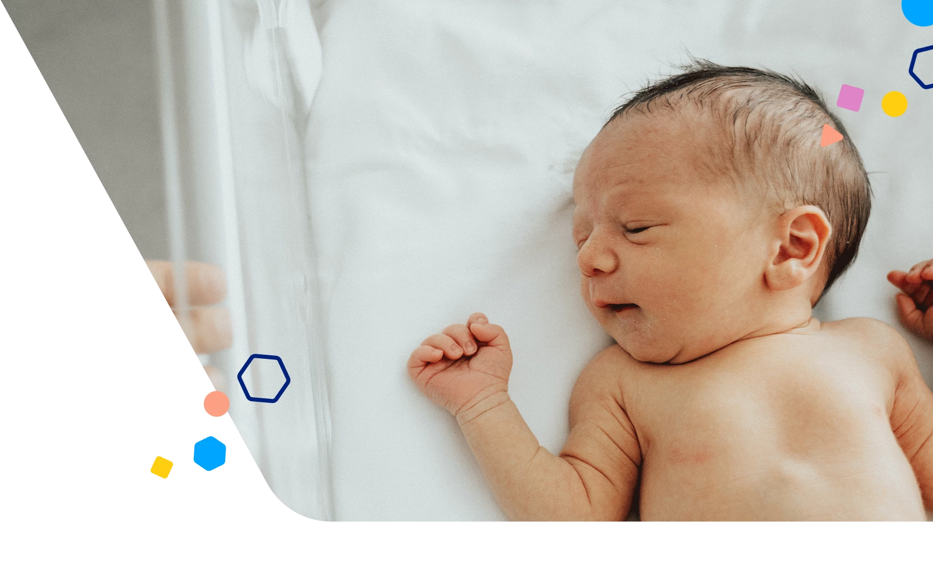 Newborn baby laying in a hospital bassinet