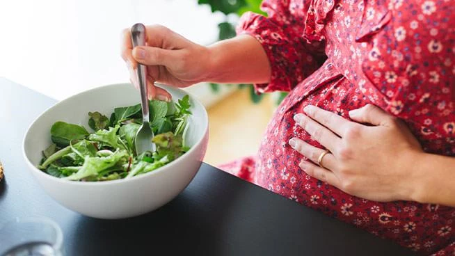 Pregnant woman eating a salad