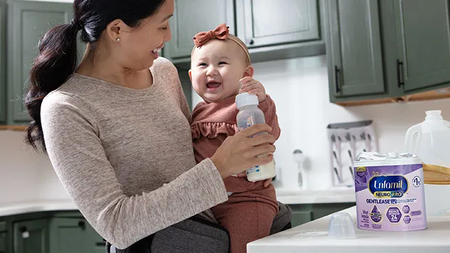 Mom holding excited baby and laughing