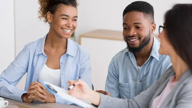 Expecting couple smiling at counseling appointment