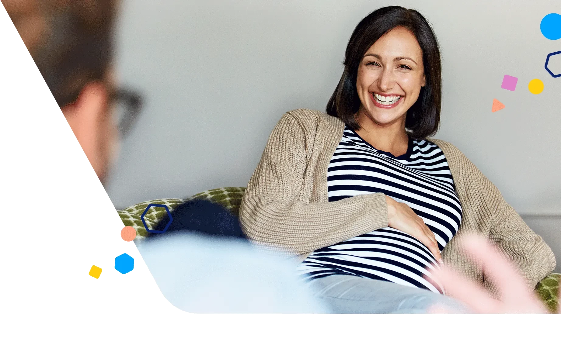 Smiling pregnant woman sitting and talking with someone