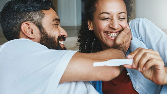 Happy couple looking at a pregnancy test