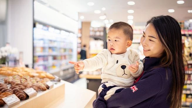 Toddler pointing at baked goods at the grocery store