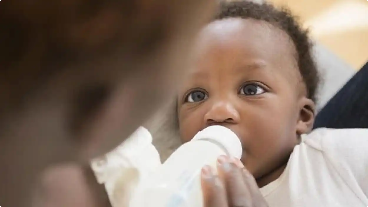 Parent feeding baby a bottle