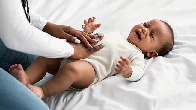 Upset baby being tended to by mother.