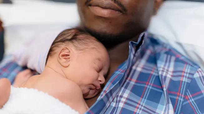 The benefits of Kangaroo care. Father laying NICU baby on bare chest to help with bonding.