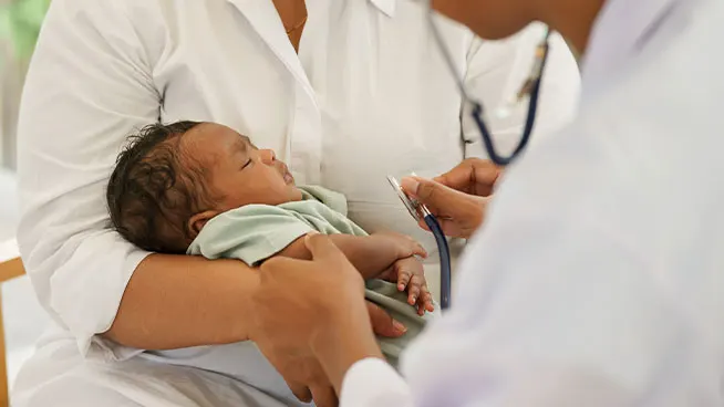 Padre sosteniendo al recién nacido durante una visita al pediatra