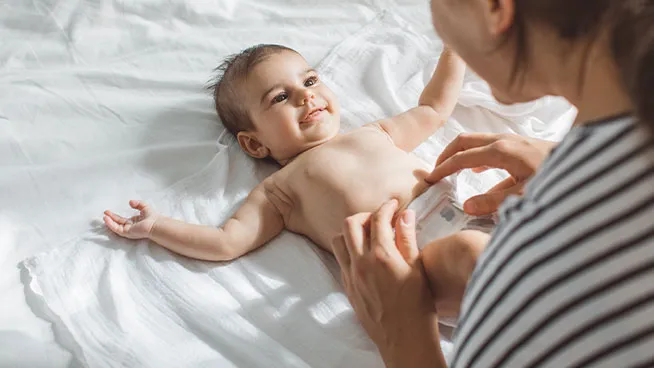 Mom tickling baby's belly