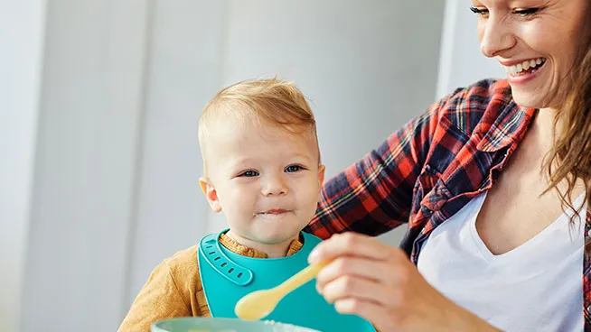 Mom spoon-feeding her baby